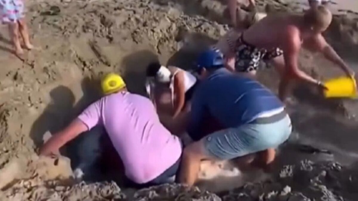Vídeo: crianças são resgatadas de 'areia movediça' após cavar buraco na praia Banhistas desesperados foram filmados tentando salvar meninos