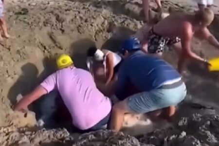 Vídeo: crianças são resgatadas de 'areia movediça' após cavar buraco na praia Banhistas desesperados foram filmados tentando salvar meninos