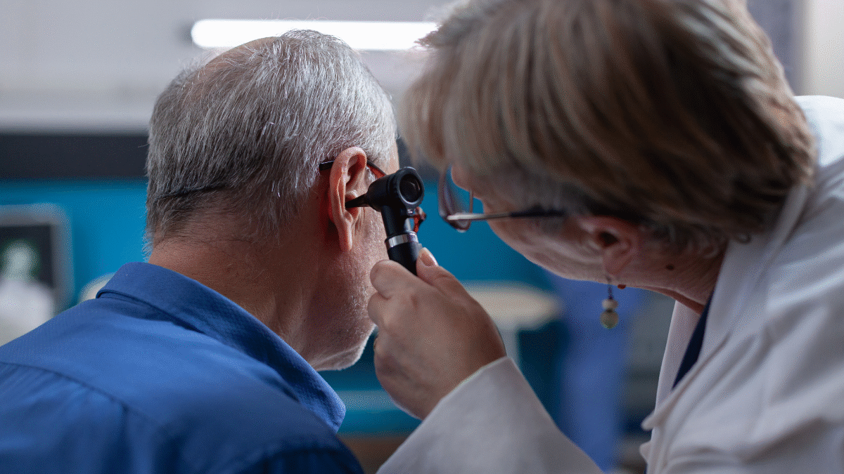 Imagem de um homem sendo atendido por uma otorrinolaringologista