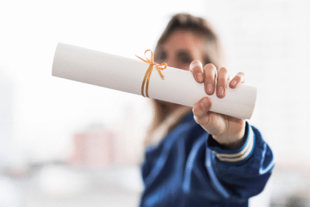 Em imagem desfocada, mulher segura diploma