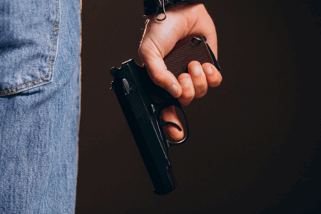 Imagem de um homem segurando uma arma de fogo