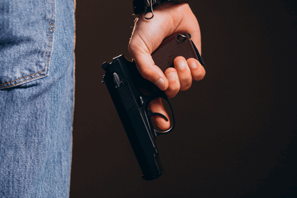 Imagem de um homem segurando uma arma de fogo