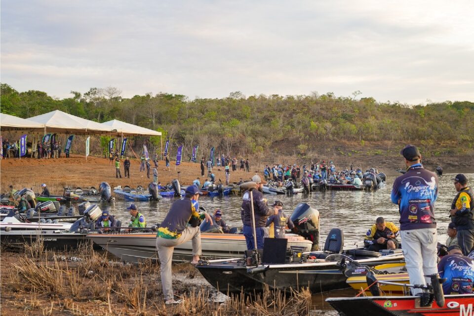 Imagem mostra competidores que participam do torneio de pesca esportiva deste ano à margem do rio