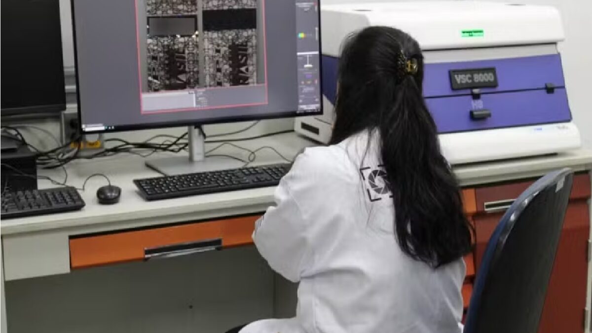 Imagem mostra profissional manipulando equipamento para checagem dos rótulos