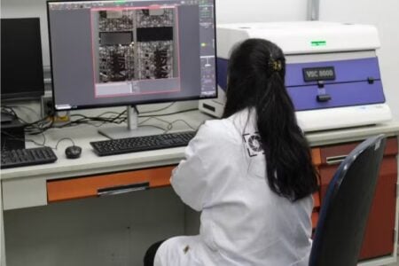 Imagem mostra profissional manipulando equipamento para checagem dos rótulos