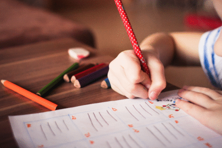 Imagem de uma criança escrevendo em papel