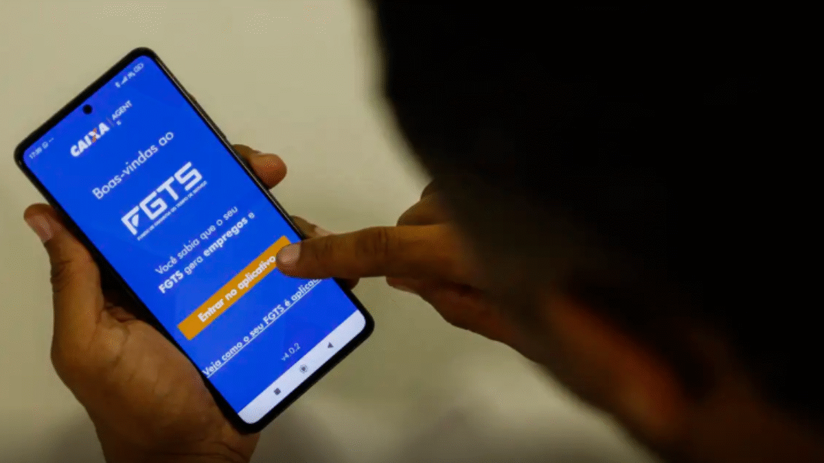 Imagem de uma pessoa com a log do FGTS no celular