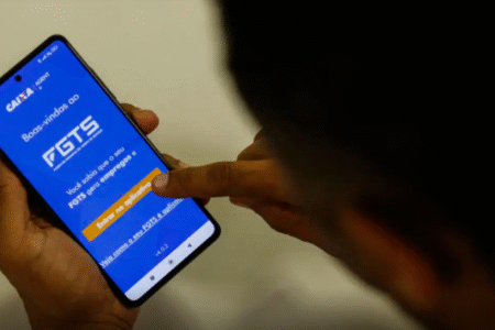 Imagem de uma pessoa com a log do FGTS no celular