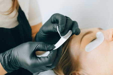 Imagem de uma mulher realizando extensão de cílios em cliente