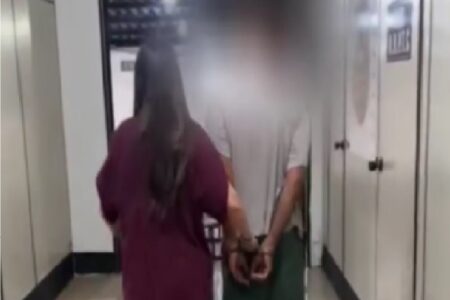 Imagem mostra policial conduzindo homem acusado de agredir e estuprar companheira