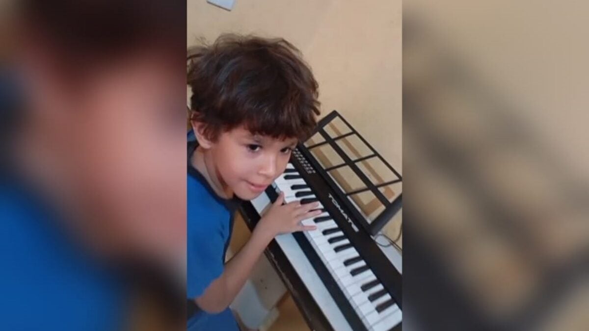 imagem do menino tocando o teclado