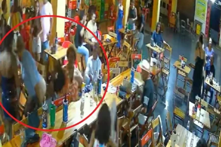 Imagem mostra mulher sentada enquanto homem abaixa as calças "e faz pum" em sua direção