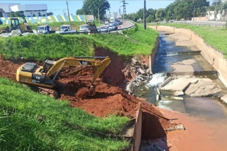 Foto mostra máquina trabalhando em trecho do Córrego Cascavel