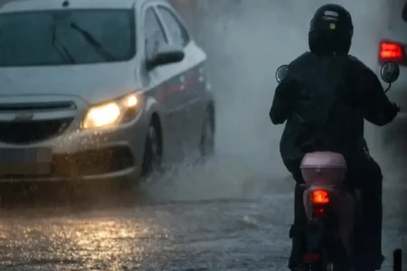 Imagem mostra veículos transitando em meio à chuva forte