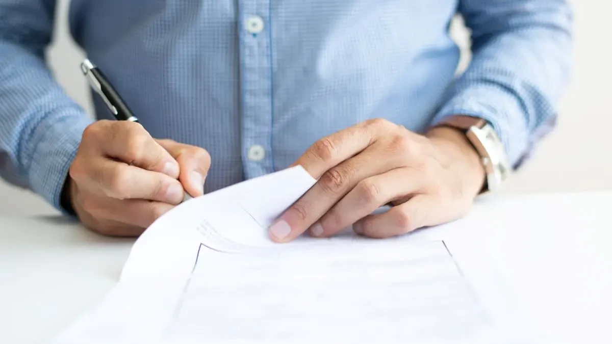 Homem assinando papel