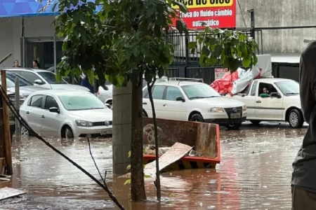 Imagem mostra carros circulando em meio a forte chuva