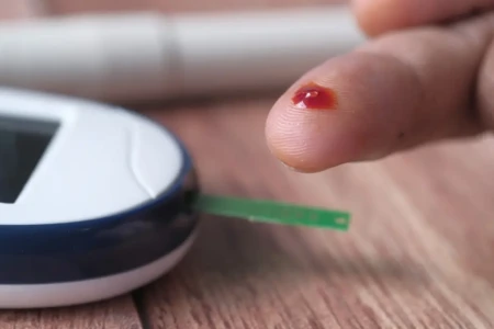 Imagem de pessoas com dedo furado para medir glicose no aparelho