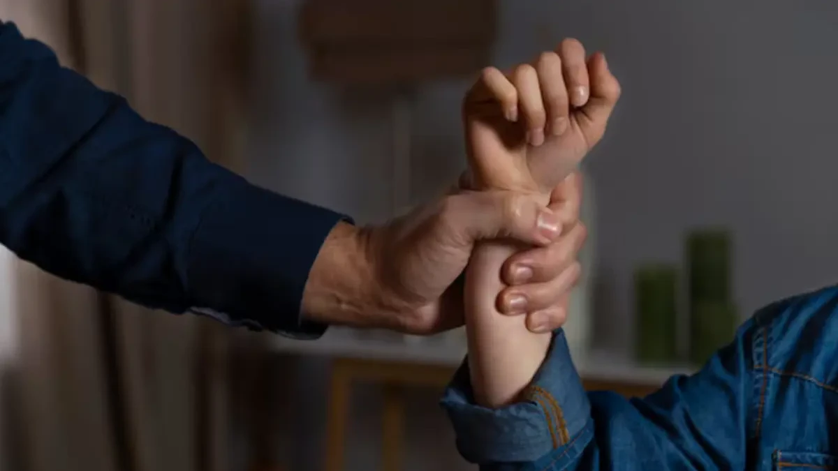 Imagem de um homem segurando o braço de uma mulher