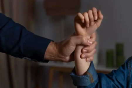 Imagem de um homem segurando o braço de uma mulher