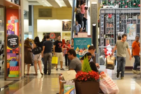 Imagem mostra consumidores circulando em shopping em busca de presentes