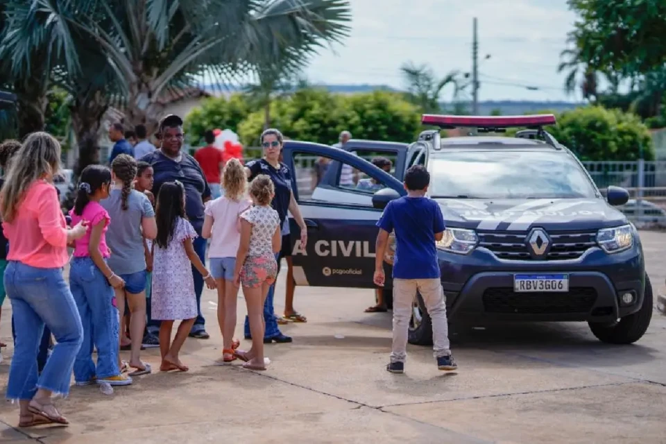 Imagem mostra crianças conhecendo viatura da Polícia Civil