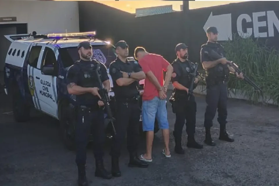 Imagem mostra menor apreendido ao lado de viatura e agentes da GCM