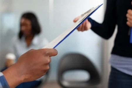 Imagem de uma pessoa entregando um currículo