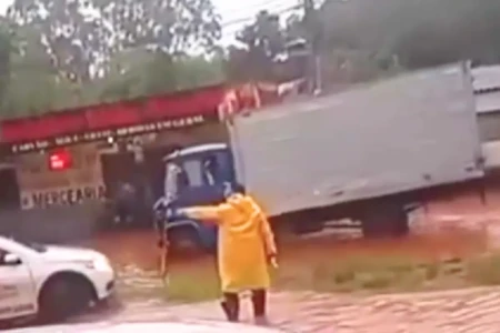 GCM saca arma para impedir que motoristas trafeguem por rua alagada em Goiânia (Foto: Reprodução)