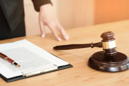 Imagem de papéis e um martelinho da justiça