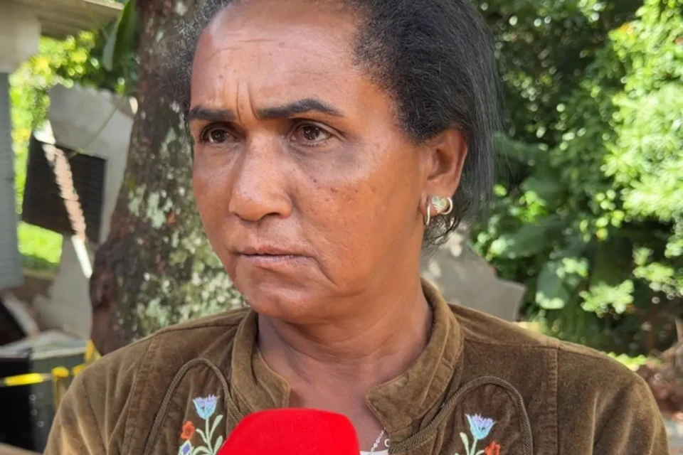 Mulher com feição triste de cabelos escuros amarrados fala ao microfone do Mais Goiás. Ao fundo, uma vegetação