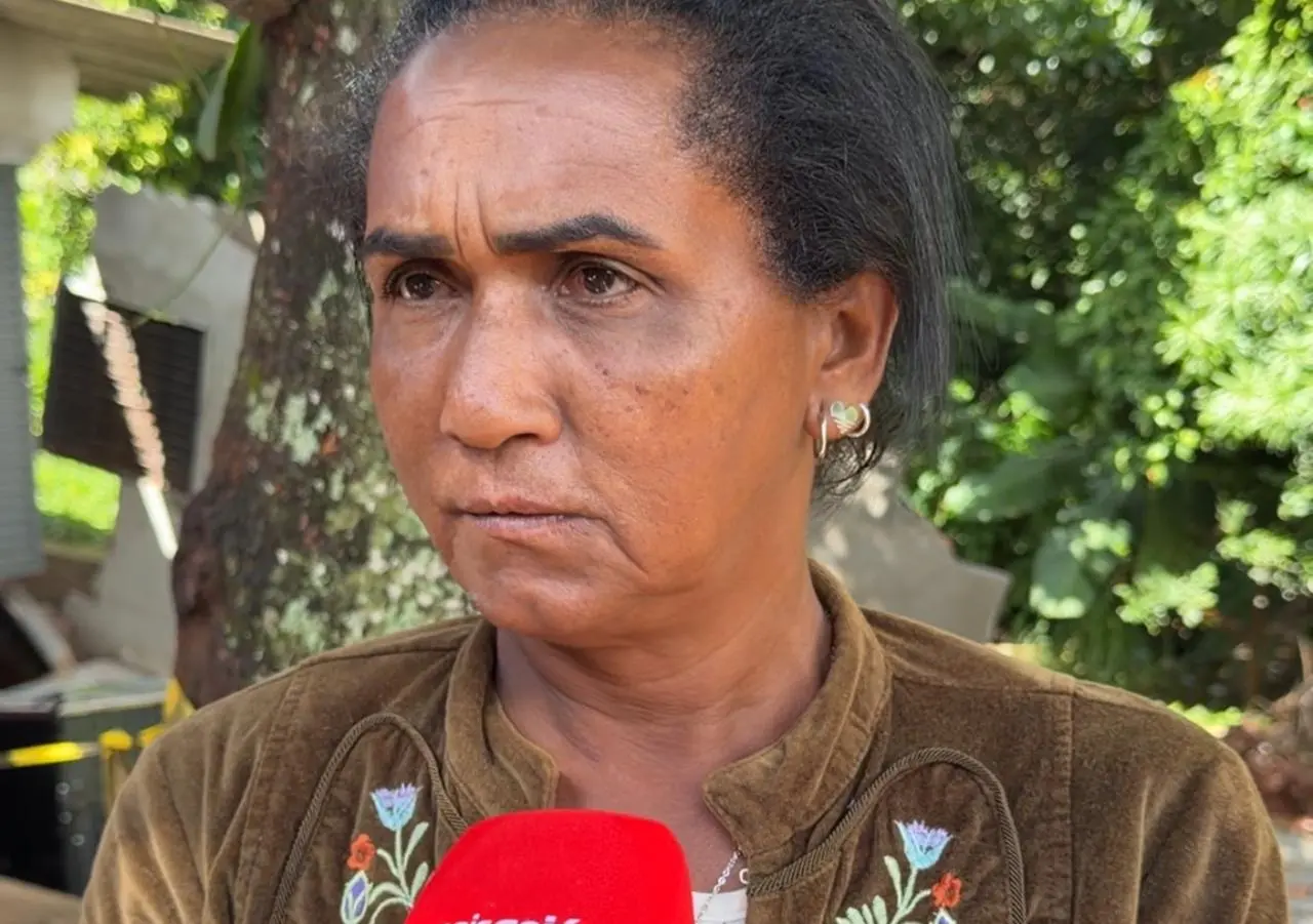 Mulher com feição triste de cabelos escuros amarrados fala ao microfone do Mais Goiás. Ao fundo, uma vegetação