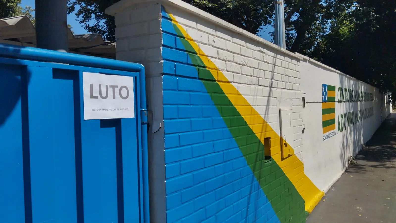 Fachada do Colégio Estadual Adoniro Martins de Andrade com placa de luto
