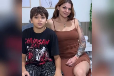 Adolescente e mulher estão sentados em cama