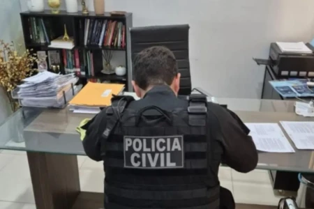 Imagem mostra agente durante cumprimento de mandado no escritório da suspeita