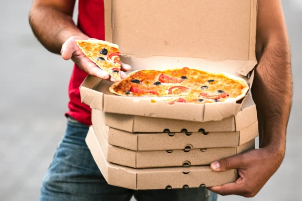 Homem segura caixa de pizzas