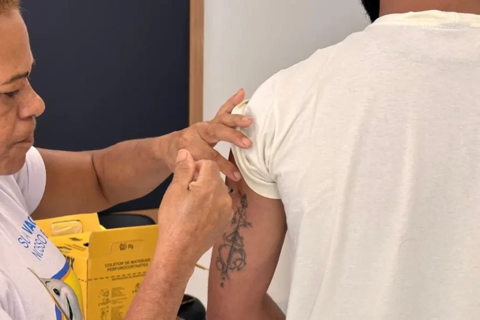 Imagem mostra trabalhador da linha de frente recebendo dose aplicada pela SMS