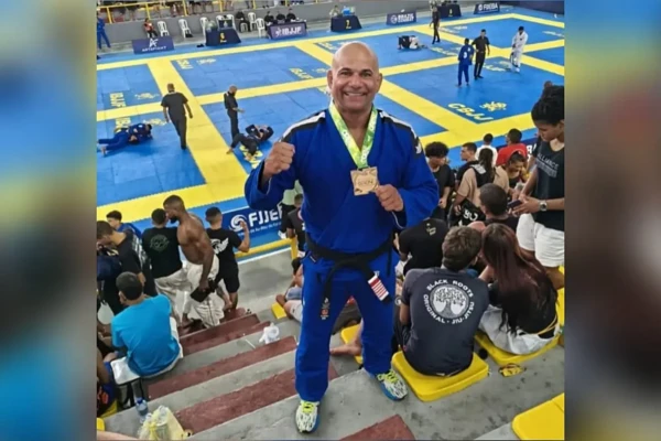 Imagem do delegado Maciel segurando a medalha de ouro