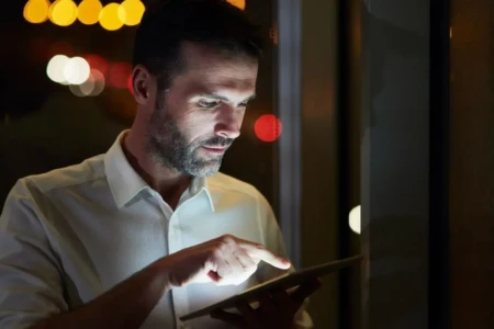 Imagem mostra homem usando dispositivo eletrônico