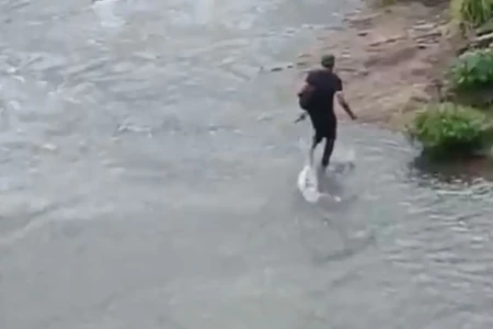 Homens enfrentam correnteza e se arriscam no córrego da marginal Botafogo, em Goiânia (Foto: Reprodução)