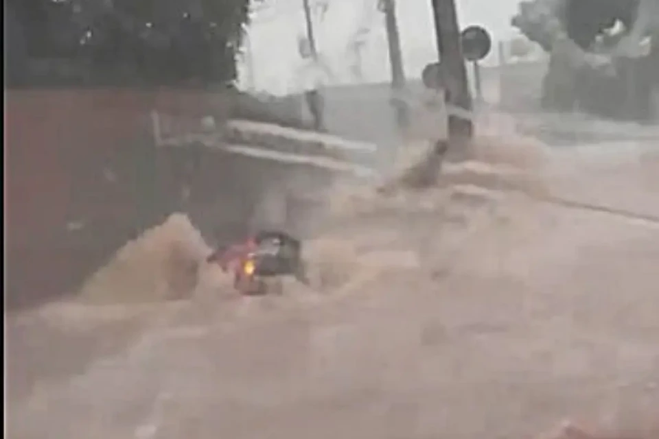 Imagem de um carro preso na enxurrada