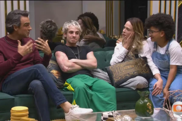 Dois homens e duas mulheres estão sentados em um sofá conversando