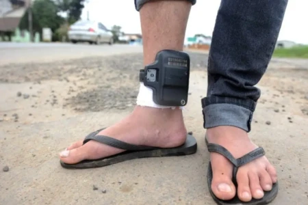 Imagem mostra homem usando tornozeleira eletrônica