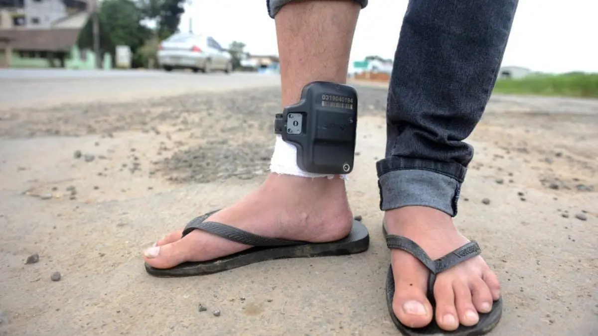 Imagem mostra homem usando tornozeleira eletrônica