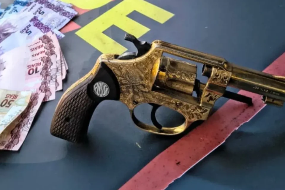 Revólver de ouro ao lado de drogas e dinheiro