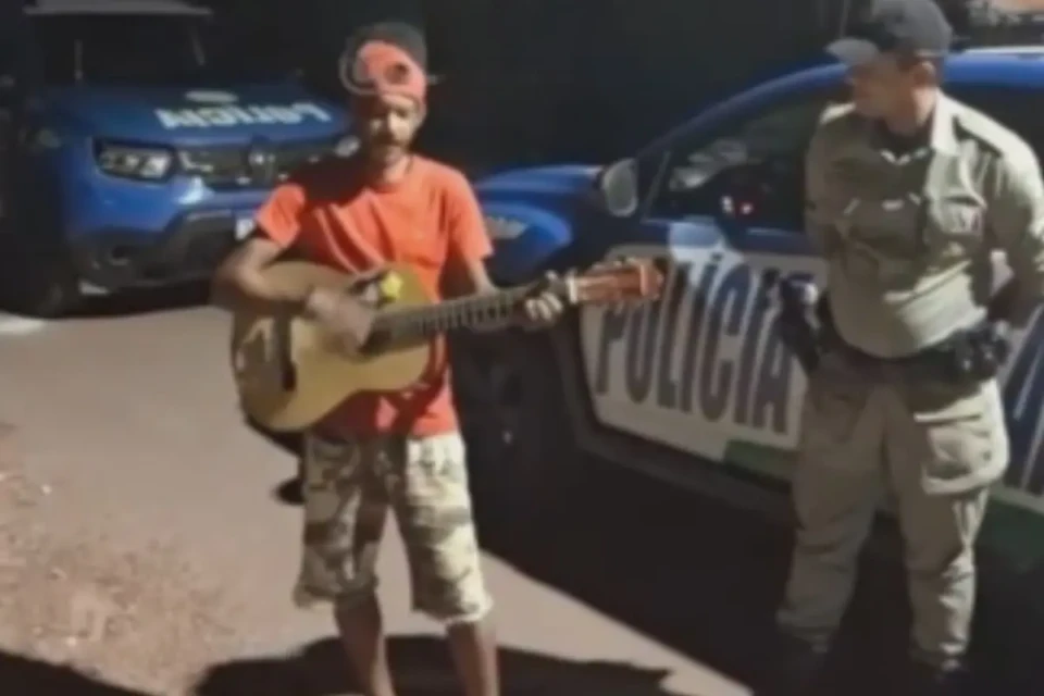 Para provar à PM que é cantor, homem toca violão durante abordagem em Porangatu (Foto: Reprodução)