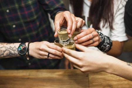 Binge drinking, excesso de consumo esporádico de álcool, aumenta risco sobre o fígado em até três vezes - foto mostra pessoas em brinde com drinks destilados