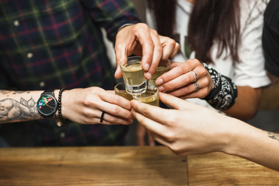 Binge drinking, excesso de consumo esporádico de álcool, aumenta risco sobre o fígado em até três vezes - foto mostra pessoas em brinde com drinks destilados