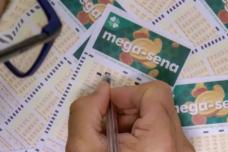 Mão preenchendo jogo da Mega-Sena