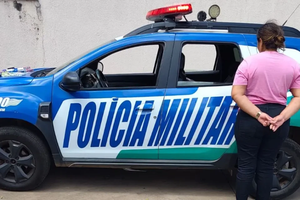 Imagem mostra mulher presa ao lado de viatura da PMGO