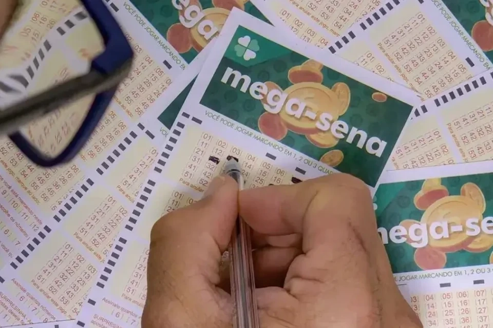 Mão preenchendo boleto da Mega-Sena